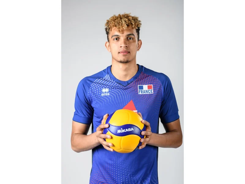 Barthélémy Chinenyeze holding a volleyball in France national team colors.