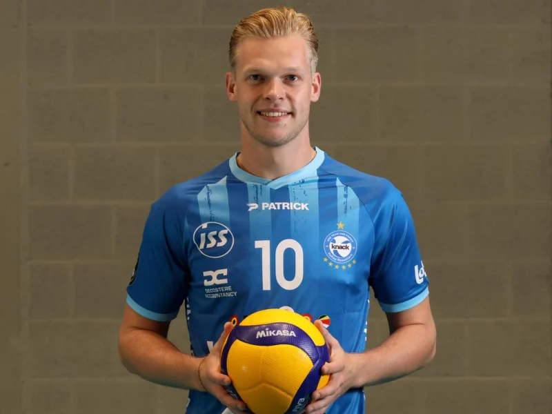 Mathijs Desmet posing in his Knack Roeselare jersey with a volleyball.